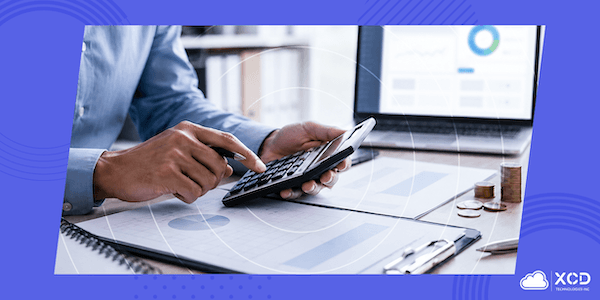Person using a calculator to review financial charts and cost data for medical conference management software.
